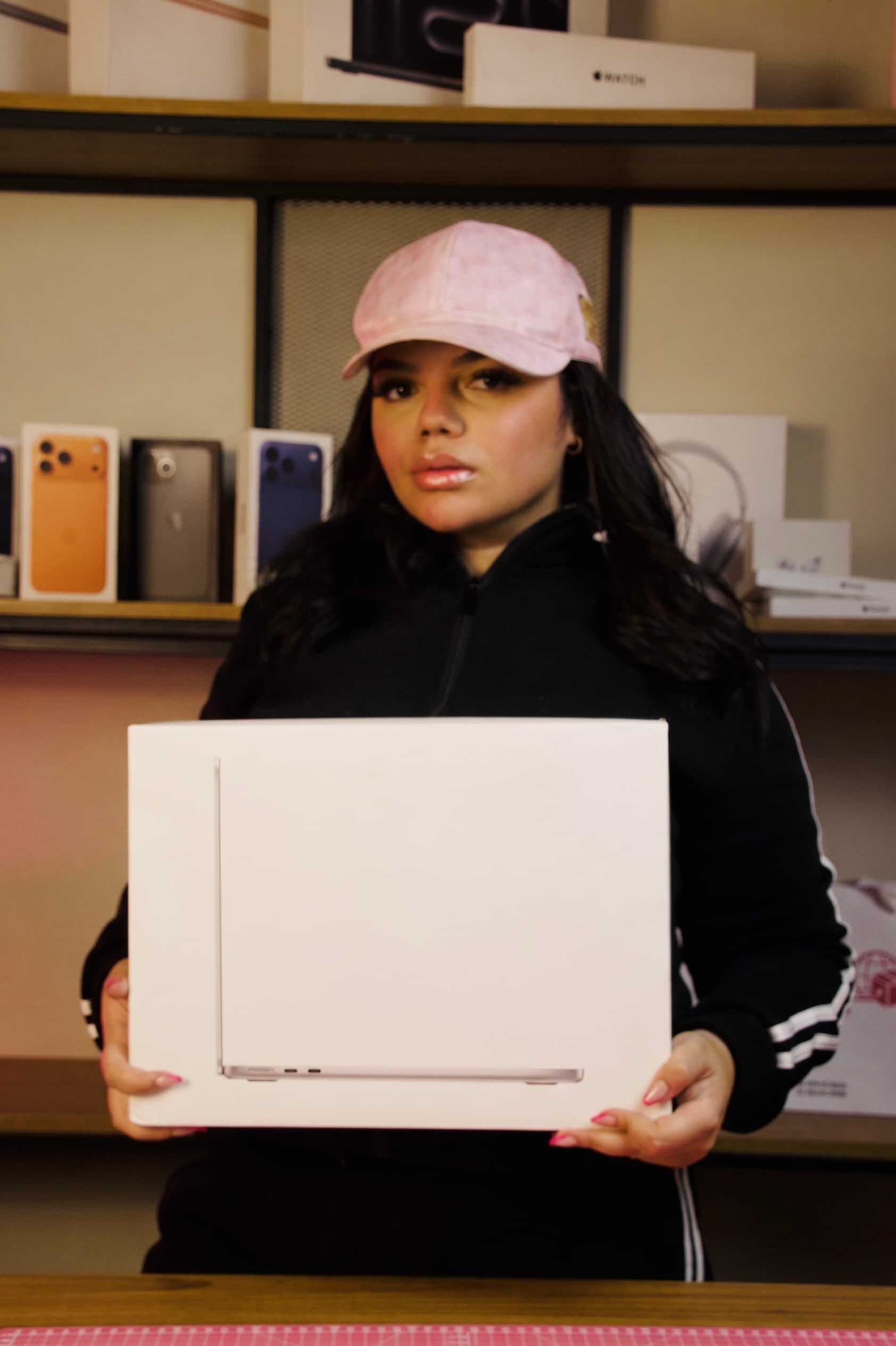 Maria Victória segurando uma caixa de MacBook no espaço da Mavi